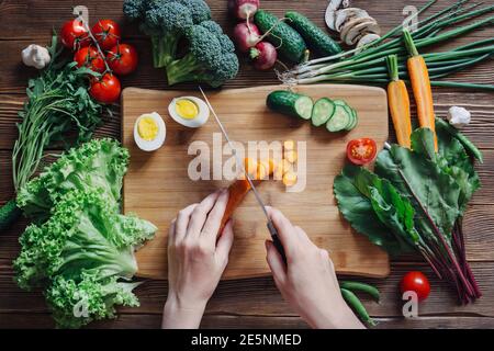 Cibo sano e verdure ingredienti con pomodoro e insalata su rustico sfondo di legno, vista dall'alto Foto Stock