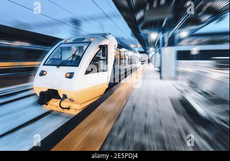 Treno ad alta velocità in movimento sulla stazione ferroviaria a. notte Foto Stock