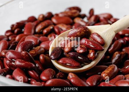 fagioli secchi in cucchiai di legno sul tavolo Foto Stock