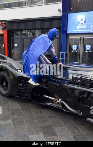 Londra, Regno Unito. 28 Gennaio 2021. Il presentatore della Capital Breakfast Roman Kemp (L) si pone accanto alla sua corsa a sorpresa Batmobile fuori dagli studi della capitale per il suo ventottesimo compleanno.Roman Kemp è stato dotato di un Batmobile come un capretto dal suo padrino George Michael e ancora lo ha. I co-ospiti Sonny e Sian lo stanno rendendo una realtà per lui. Credit: SOPA Images Limited/Alamy Live News Foto Stock