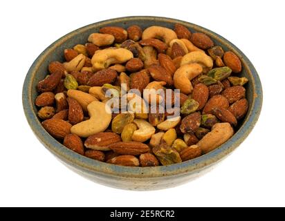 Vista laterale del pistacchio, delle mandorle e delle noci di anacardi in una ciotola di gres isolata su sfondo bianco. Foto Stock