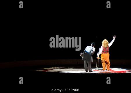 Due clown con la loro schiena alla telecamera ondano alla folla nel circo durante un atto per l'American Circus, Italia, 2011 Foto Stock