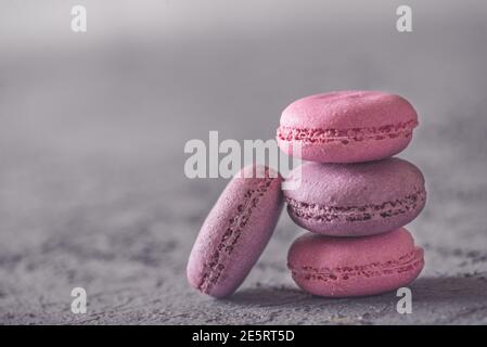 Bella colorata deliziosi dessert makarons, stack sulla pietra grigia sullo sfondo Foto Stock
