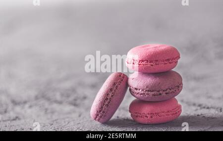 Bella colorata deliziosi dessert makarons, stack sulla pietra grigia sullo sfondo Foto Stock