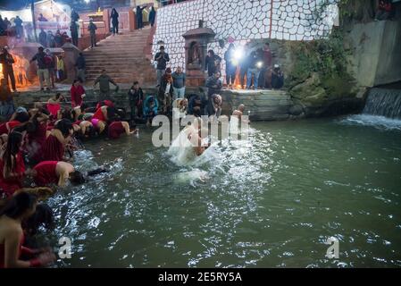 Kathmandu, Nepal. 28 Gennaio 2021. I devoti indù eseguono rituali mentre bagni nel fiume Shali durante il festival Swasthani Brata katha. Madhav Narayan festival o Swasthani Brata katha è un festival in cui i devoti recitano sacre scritture dedicate alla dea indù Swasthani e Lord Shiva. Le donne indù nepalesi che non sono sposate pregano per un buon marito mentre sono sposate pregano per la lunga vita del loro marito. Credit: SOPA Images Limited/Alamy Live News Foto Stock