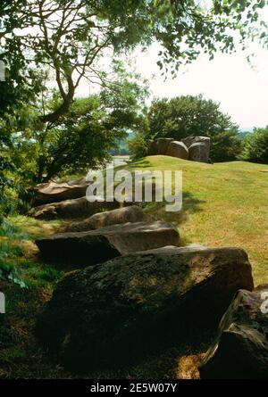 Vista se dalla parte posteriore del Barrow lungo del Neolitico di Coldrum, Kent, Inghilterra, Regno Unito, che mostra pietre arrotondate di boulder di sarsen, e la camera di sepoltura all'estremità E. Foto Stock