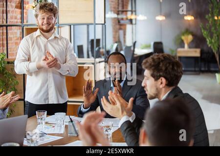 Mani che si aggrappano. Gruppo diversificato di collaboratori che hanno una discussione informale in ufficio. Dirigenti durante discussioni amichevoli, rapporti mensili, incontri creativi. Concetto di business, finanza, occupazione, lavoro. Foto Stock