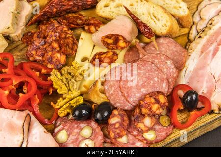 Vari tipi di salame, speck e salsicce su un tavolo di legno. Cibo spazzatura grasso. Carne affumicata. Concetto di obesità. Sovrappeso. Foto Stock