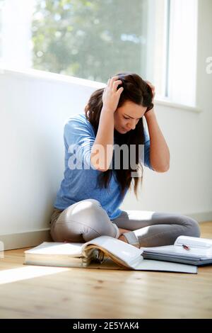 Studentessa sedette sul pavimento per studiare Foto Stock