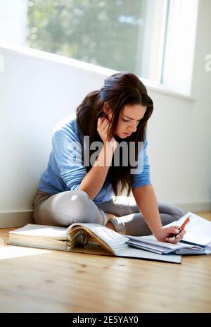 Studentessa sedette sul pavimento per studiare Foto Stock