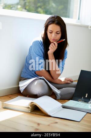 Studentessa sedette sul pavimento per studiare Foto Stock