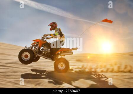 Ritratto di uomo quad in bicicletta nel dessert con luce lente Foto Stock