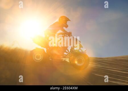 Ritratto di uomo quad in bicicletta nel dessert con luce lente Foto Stock