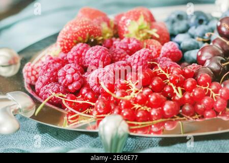 Bacche fresche mature piuttosto multicolore su piatto per mangiare gustoso Foto Stock