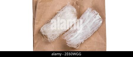 Vista dall'alto di diversi rotoli di tagliatelle di vermicelli di fagioli mung essiccati, o tagliatelle di cellofano, ricche di proteine e senza glutine disposte su una tavola di legno Foto Stock