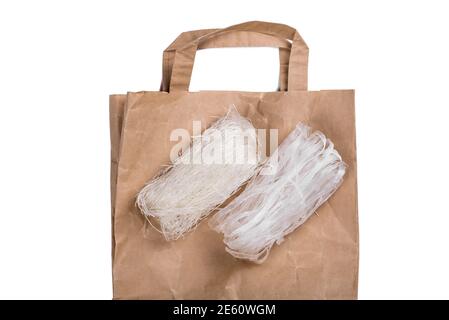 Vista dall'alto di diversi rotoli di tagliatelle di vermicelli di fagioli mung essiccati, o tagliatelle di cellofano, ricche di proteine e senza glutine disposte su una tavola di legno Foto Stock