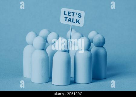 Piccole figure in legno con un concetto di poster Let's Talk Foto Stock