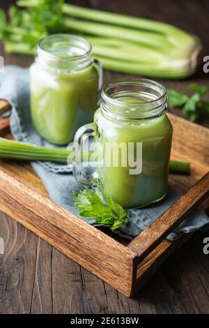 Succo di sedano puro appena fatto in vasetti di vetro su legno sfondo Foto Stock