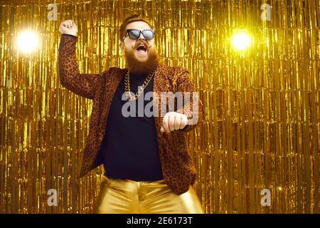 Felice uomo bearded in vestito pazzo danzante gangnam stile e. divertirsi in una festa Foto Stock