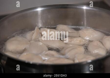 Cottura gnocchi con carne bollendo in acqua in una padella, dettagli, closeup. Foto Stock