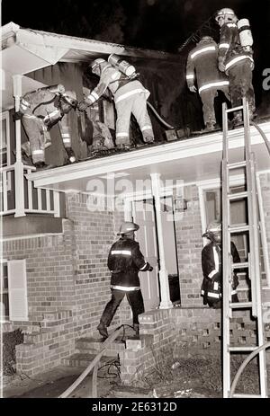 Vigili del fuoco al lavoro. Un vigile del fuoco è un soccorritore ampiamente addestrato in vigili del fuoco, principalmente per estinguere incendi pericolosi che minacciano la vita, la proprietà e l'ambiente, nonché per salvare persone e in alcuni casi o giurisdizioni anche animali da situazioni pericolose. I vigili del fuoco maschili sono talvolta indicati colloquialmente con il termine storico pompiere (e, meno comunemente, una vigile del fuoco femminile con il termine pompiere) anche se l'uso di questa terminologia è ufficialmente scoraggiato. L'estinzione degli incendi è ulteriormente suddivisa in competenze che includono: Dimensioni, spegnimento, ventilazione, Foto Stock