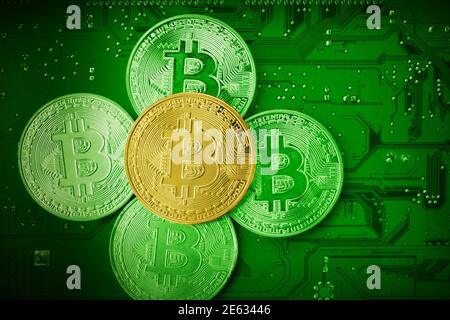 Bitcoins d'oro su una scheda madre. Vista dall'alto. Foto Stock