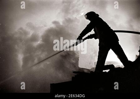 Vigili del fuoco al lavoro. Un vigile del fuoco è un soccorritore ampiamente addestrato in vigili del fuoco, principalmente per estinguere incendi pericolosi che minacciano la vita, la proprietà e l'ambiente, nonché per salvare persone e in alcuni casi o giurisdizioni anche animali da situazioni pericolose. I vigili del fuoco maschili sono talvolta indicati colloquialmente con il termine storico pompiere (e, meno comunemente, una vigile del fuoco femminile con il termine pompiere) anche se l'uso di questa terminologia è ufficialmente scoraggiato. L'estinzione degli incendi è ulteriormente suddivisa in competenze che includono: Dimensioni, spegnimento, ventilazione, Foto Stock