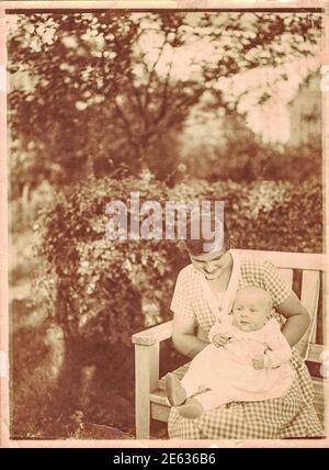 GERMANIA - CIRCA 1940: La foto d'epoca mostra la mamma e la sua bambina. Il bambino ha 6 mesi di età. Foto con effetto seppia. Foto Stock