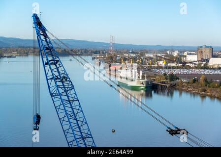 Ditrict industriale a Portland, Oregon, con una gru in primo piano e il fiume Willamette Foto Stock