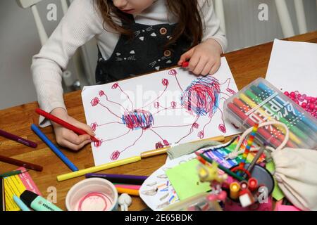 Una giovane ragazza ha ritratto disegnando un bug di Coronavirus durante la scuola di casa e Lockdown 3 a Sussex, Regno Unito. Foto Stock