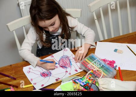 Una giovane ragazza ha ritratto disegnando un bug di Coronavirus durante la scuola di casa e Lockdown 3 a Sussex, Regno Unito. Foto Stock