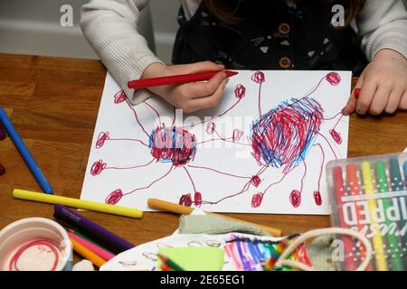 Una giovane ragazza ha ritratto disegnando un bug di Coronavirus durante la scuola di casa e Lockdown 3 a Sussex, Regno Unito. Foto Stock