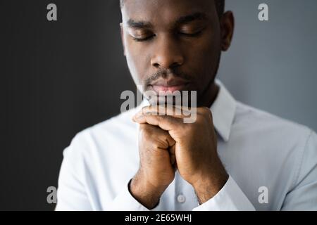 L'uomo afro-americano che prega e cerca Dio Foto Stock