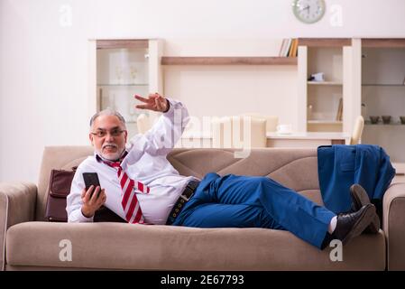 Capo di lavoro maschile senior dipendente venire a casa dal lavoro Foto Stock