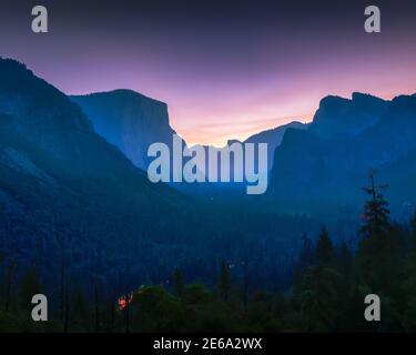 Alba rosa a Tunnel View a Yosemite. Luci auto in valle. Foto Stock