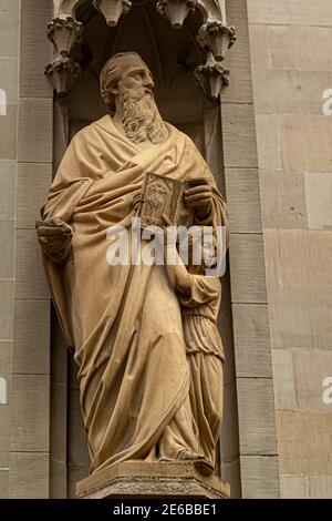 Antica statua di San Lorenzo tenendo una bibbia in mano con un bambino accanto a lui, all'angolo di San Laurenzen Kirche (St Lawrence Church) un istore Foto Stock