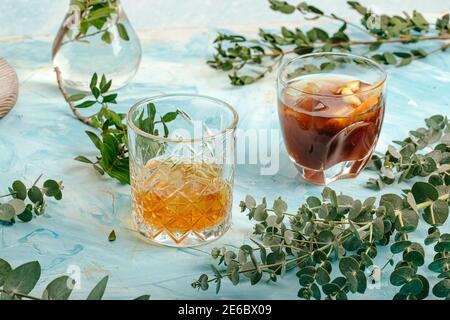 Due bicchieri di diverse bevande alcoliche su blu Foto Stock