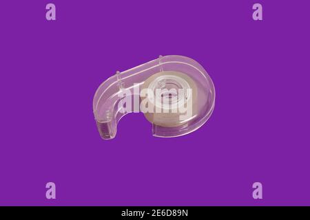dispenser di nastro scotch isolato su sfondo viola Foto Stock