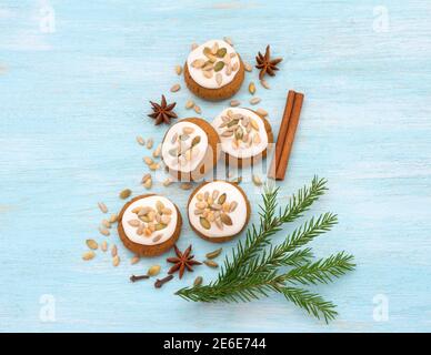 Pan di zenzero di Natale al miele profumato con smalto, noci e semi su sfondo azzurro con spezie, chiocciola Foto Stock