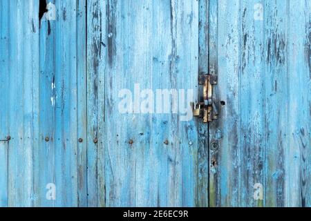 Affondare il vecchio cancello blu con una toppa e un lucchetto con ferro arrugginito. Copspace Foto Stock