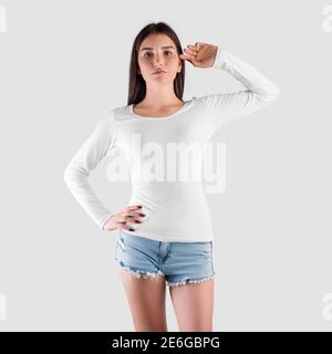 Mockup di una felpa bianca con manica lunga su una ragazza di aspetto caucasico, in pantaloncini denim, pullover per la presentazione del design. Casual donne cl Foto Stock