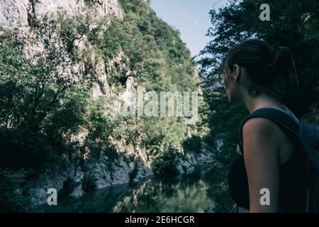 Ragazza che cammina lungo un piccolo sentiero nella montagna di Sadernes, Spagna. In una soleggiata giornata estiva Foto Stock