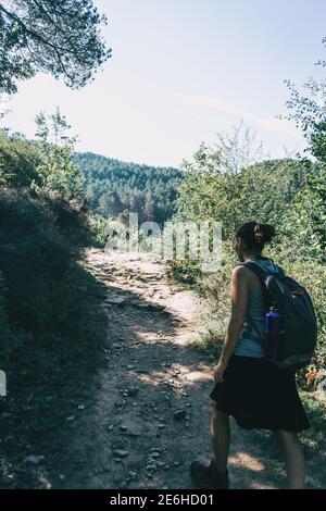 donna che cammina lungo un piccolo sentiero in montagna Foto Stock