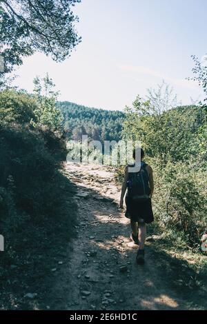 donna che cammina lungo un piccolo sentiero in montagna Foto Stock