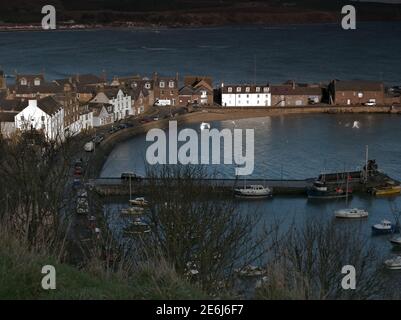 Porto di Stonehaven al sole d'inverno che illumina gli edifici imbiancati Foto Stock