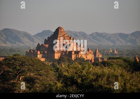 BAGAN, MYANMAR - 18 NOVEMBRE 2015: Antico tempio orientale in terreno verde, vista di bella pietra Dhammayangyi in verde ampio terreno, montagna Foto Stock