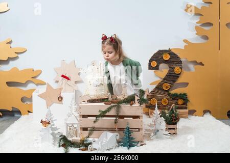 Immagini Stock - Decorazioni Di Compleanno Invernali Per Bambini. 2 Anni.  Bambina Sveglia In Un Cardigan Verde Vicino Alla Torta Di Compleanno  Bianca. Image 167531424