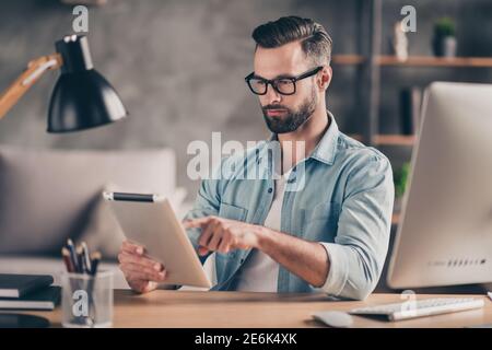 Ritratto fotografico dell'uomo che utilizza un tablet che lavora al tavolo moderno ufficio industriale al chiuso Foto Stock