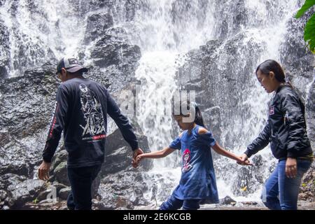 Città di Batu, Indonesia. Novembre 2020. La famiglia sta godendo la freschezza della cascata Watu Lumpang. Genitori e bambini sono in vacanza in fresco Foto Stock