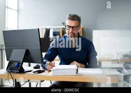 Consulente contabile fiscale uomo che fa contabilità fatture vendite Foto Stock